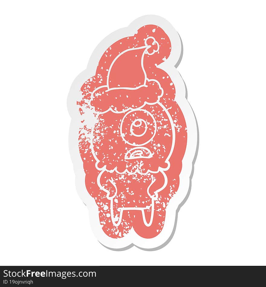 quirky cartoon distressed sticker of a cyclops alien spaceman wearing santa hat