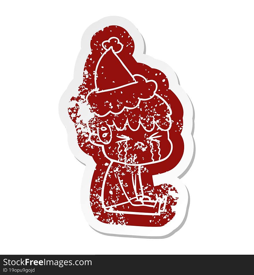 quirky cartoon distressed sticker of a boy crying wearing santa hat