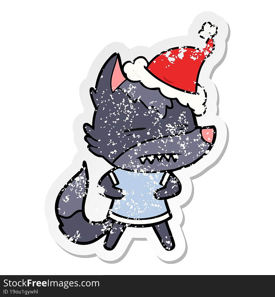 hand drawn distressed sticker cartoon of a wolf showing teeth wearing santa hat