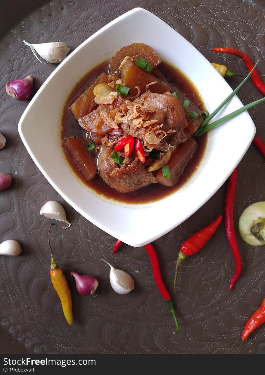 soup in a white bowl with chilli and onion for decoration