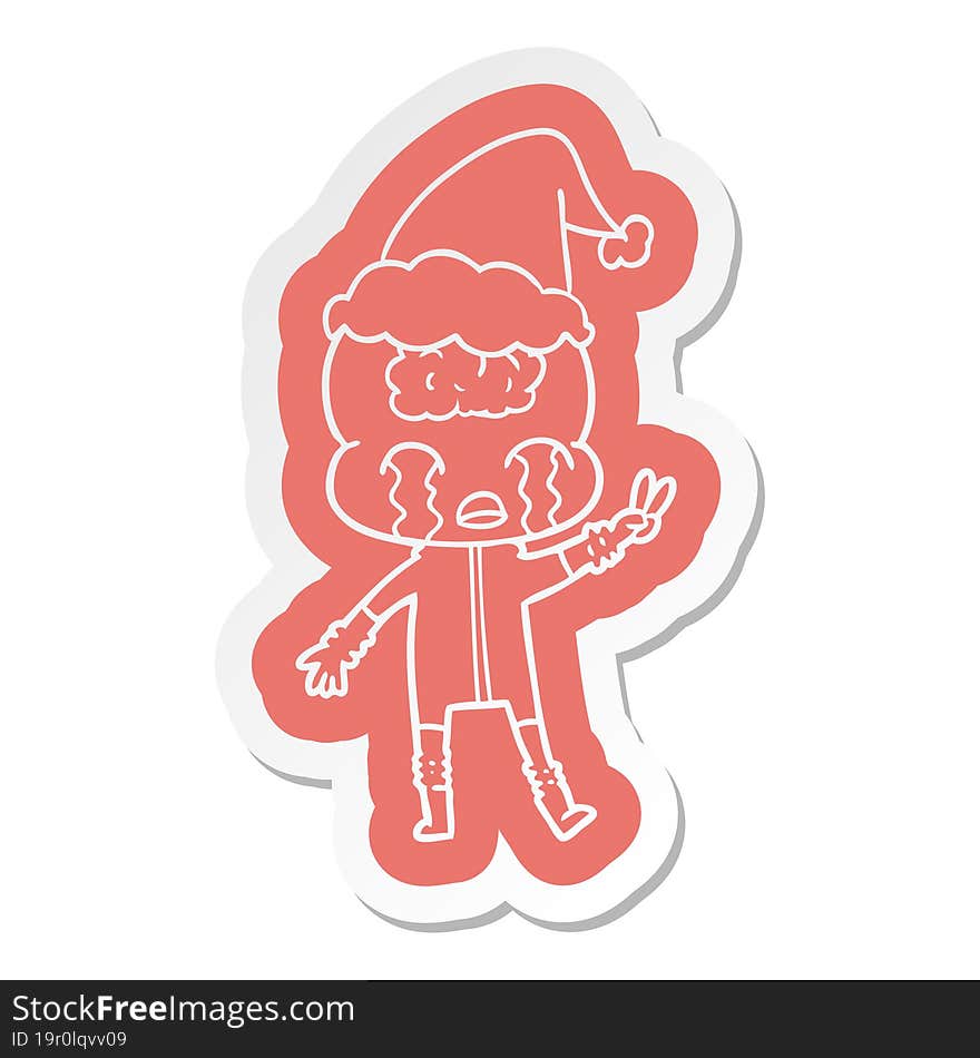 Cartoon  Sticker Of A Big Brain Alien Crying And Giving Peace Sign Wearing Santa Hat