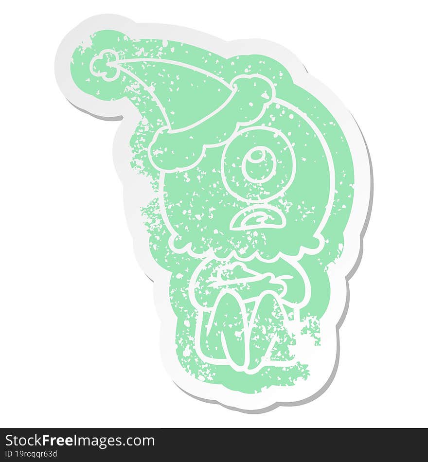 cartoon distressed sticker of a cyclops alien spaceman wearing santa hat