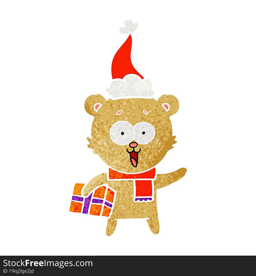 laughing teddy  bear with christmas present wearing santa hat