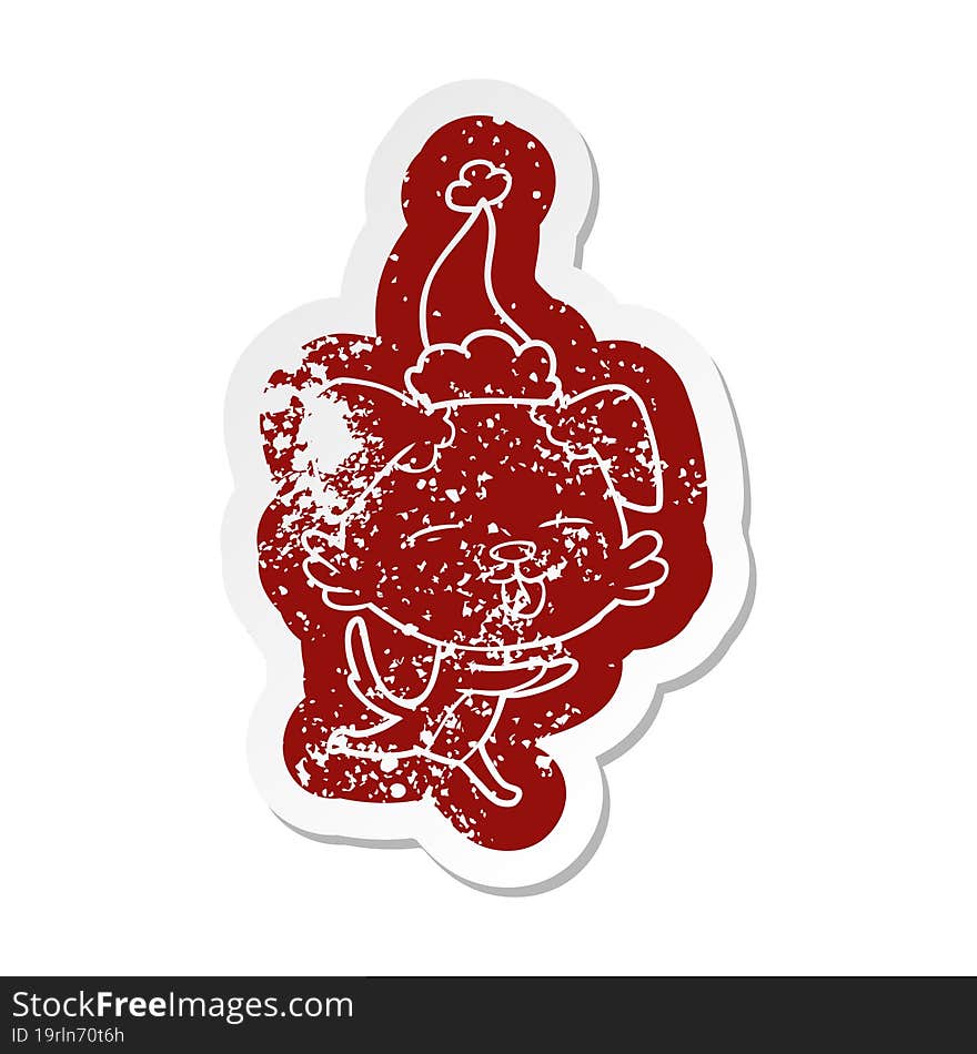 quirky cartoon distressed sticker of a dog sticking out tongue wearing santa hat