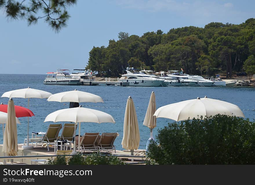 A small tourist resort in Cikat Bay in Mali Losinj, umbrellas, sea and yacht