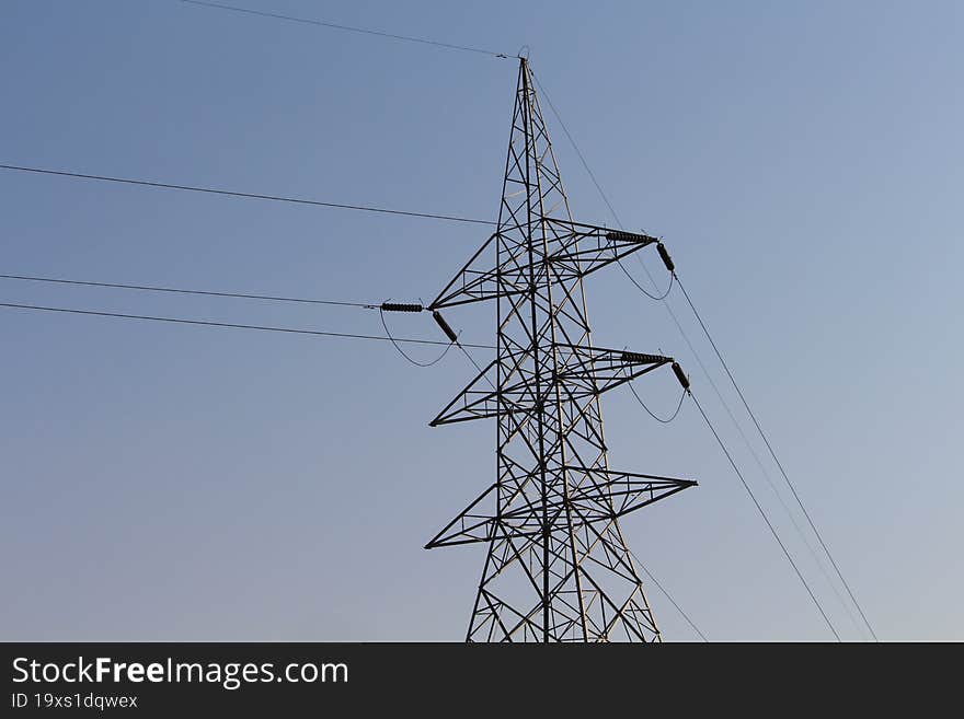a high voltage electricity transmission setup with poles and wires
