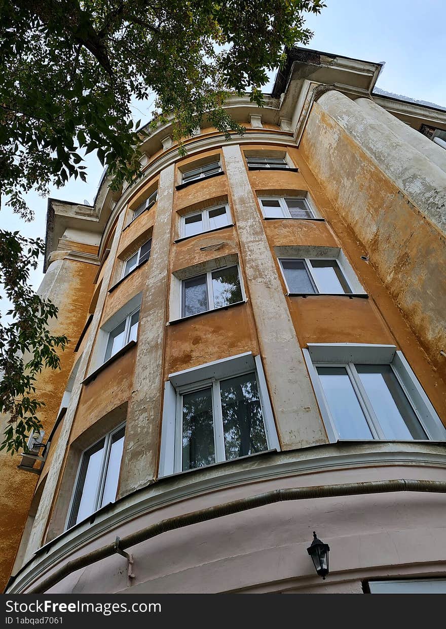 Old orange house with a round facade in the style of constructivism