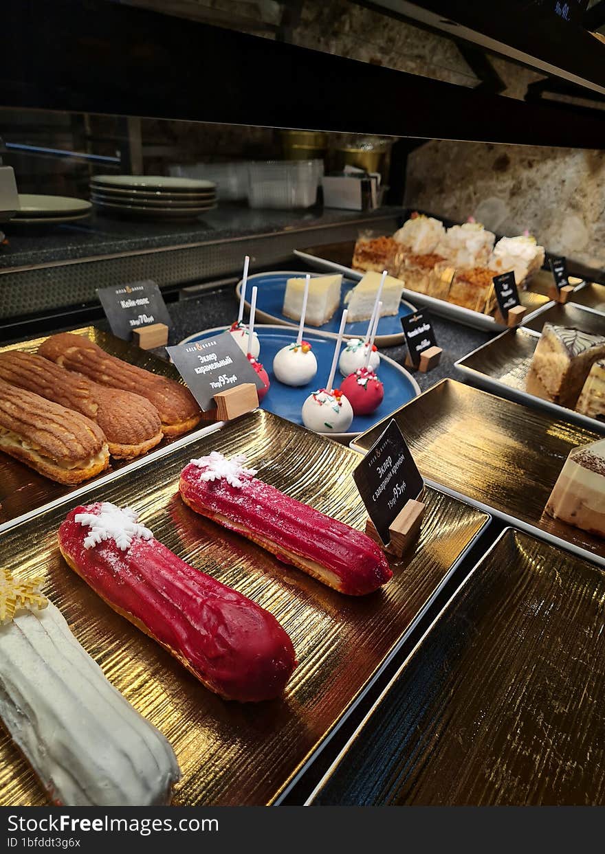 Different desserts in golden trays on display