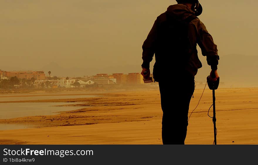 Man Detecting the Beach for Precious Metals