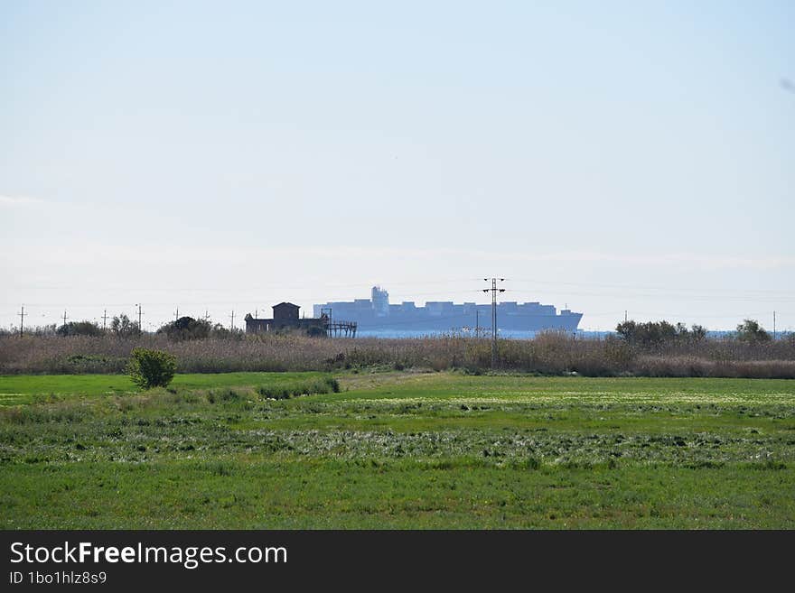 Container ship sailing along the coast.