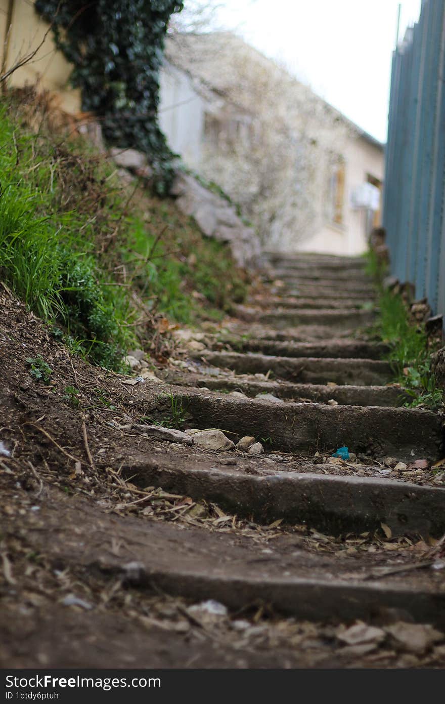 An old staircase on the street. The old district of the city on a hill. Dirty stairs.