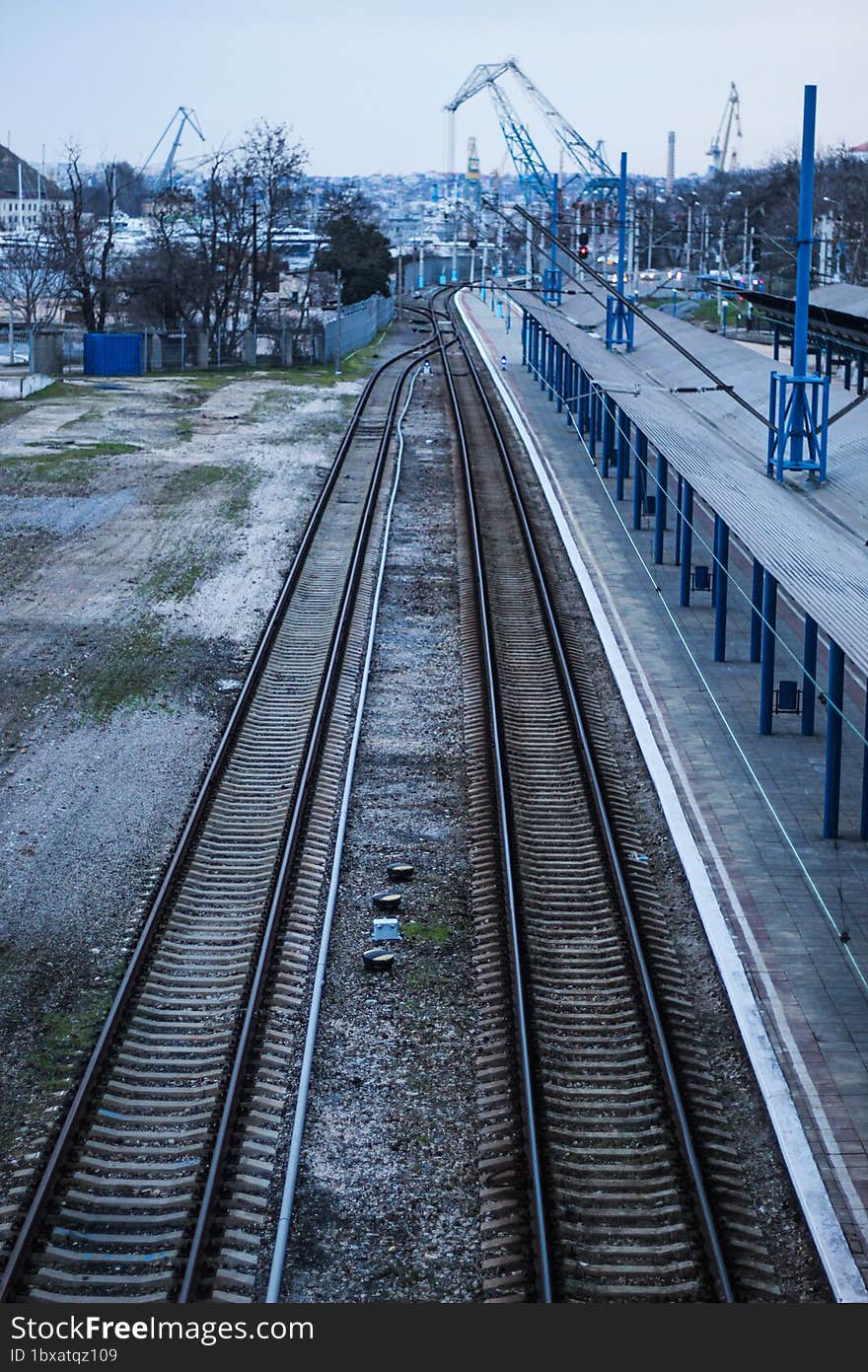 Empty railway station platform. Blue columns at the train station. Top view of the railway.