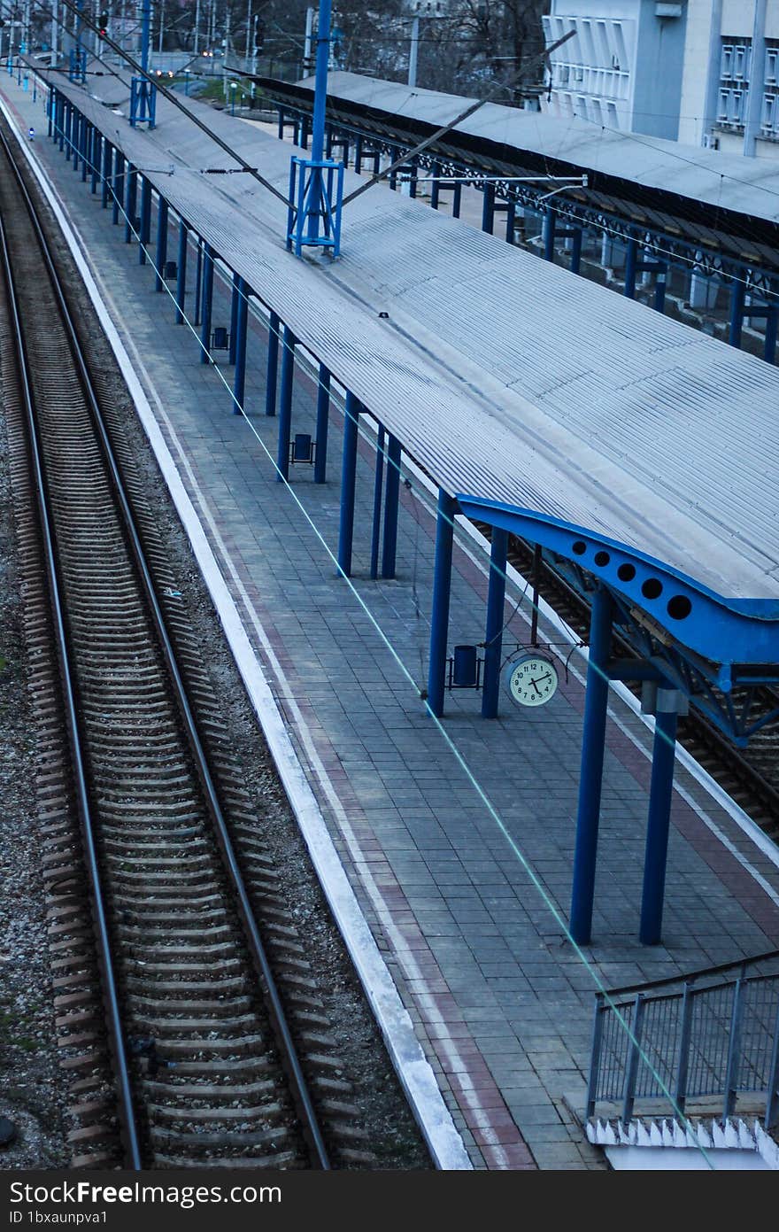 Empty railway station platform. Blue columns at the train station. Top view of the railway.