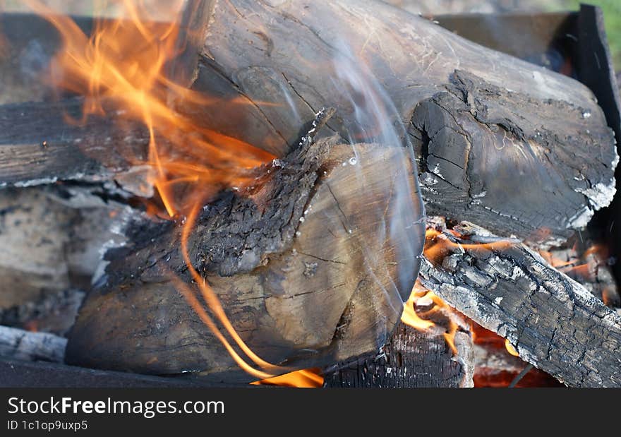 Bonfire. Orange flame of a fire. Bonfire on the grill with smoke. Arson or natural disaster. Bonfire close. Fire in nature. Bonfire background.