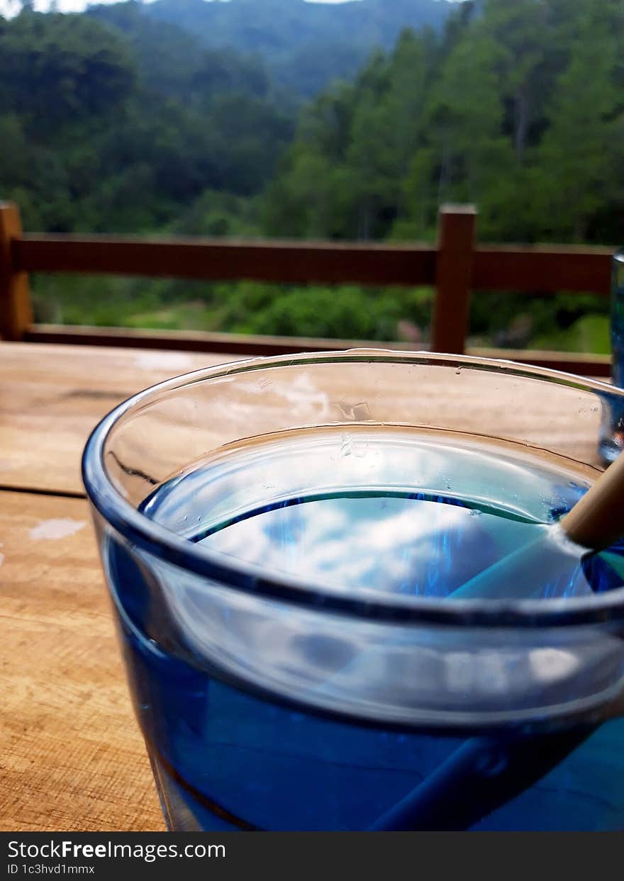 enjoy morning on top of hill with green trees view with blue drink