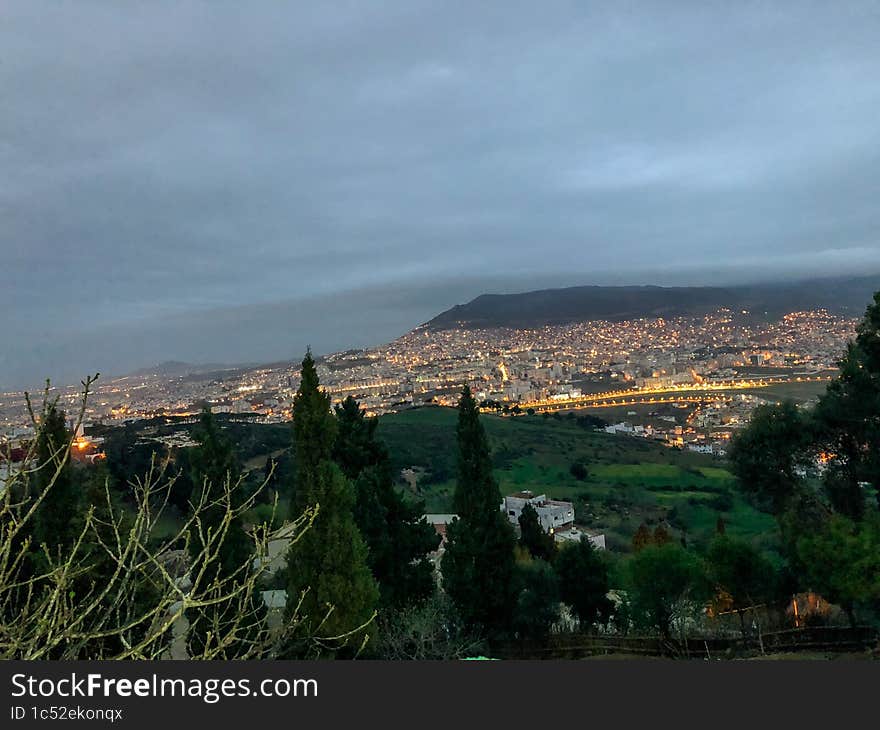 Mesmerizing and illuminating night view of the bustling city of Tetouan, capturing its stunning cityscape and illuminating skyline under the cloudy