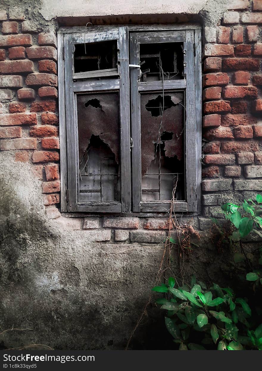 Broken vintage window in brick wall