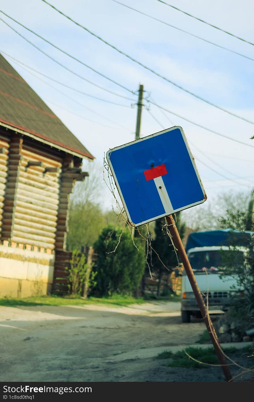 An old beveled road sign.  The iconic designation & x22 dead end& x22 . Rural road. An old truck in the background.