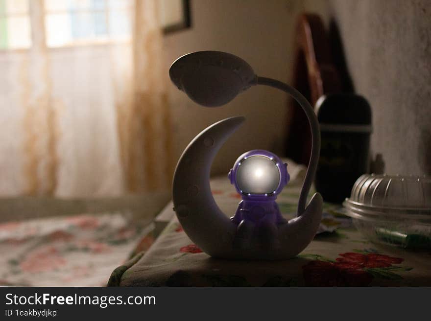 A white robot with a lamp on the background of a book.