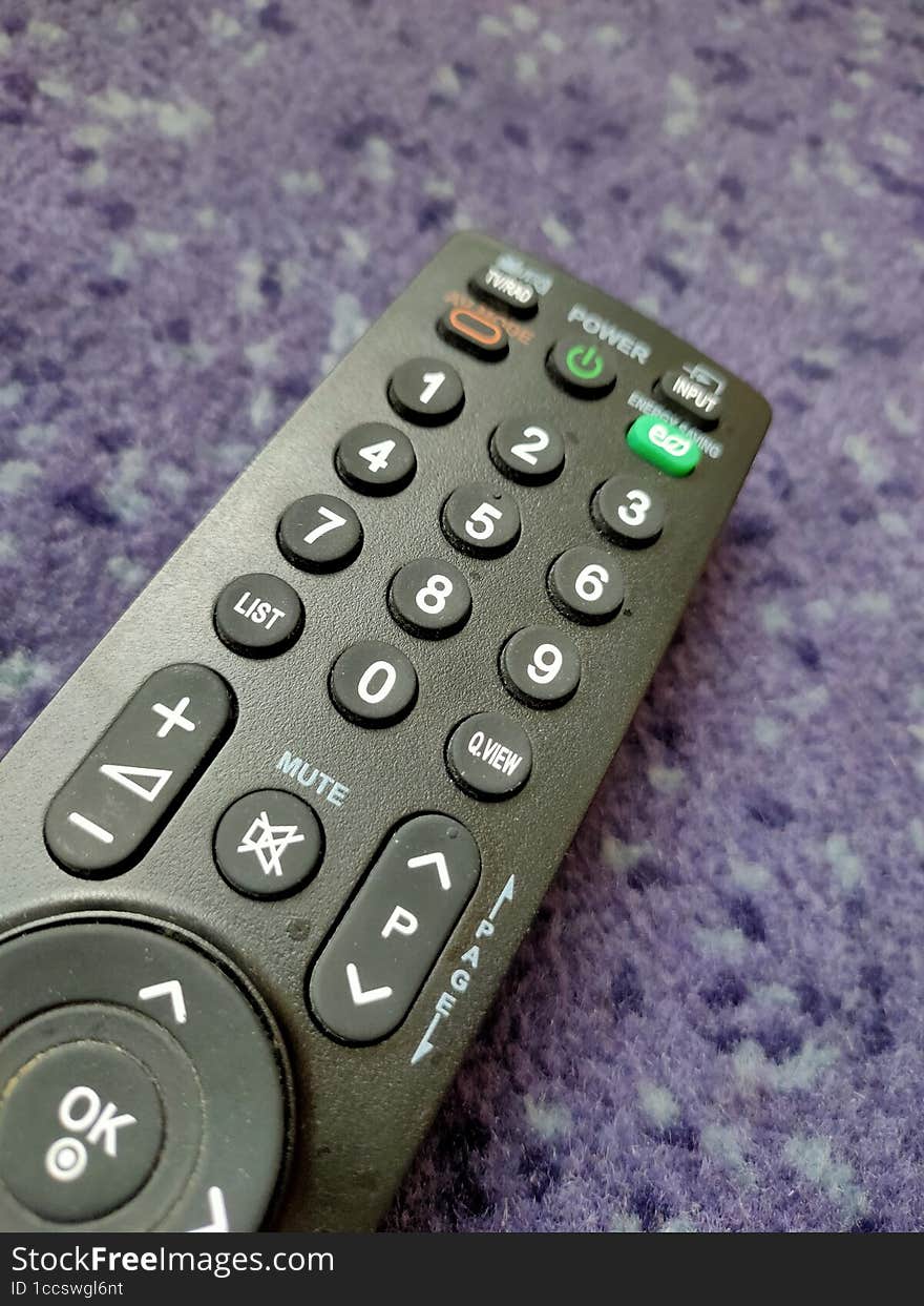 Television Remote Lying on Purple Carpet