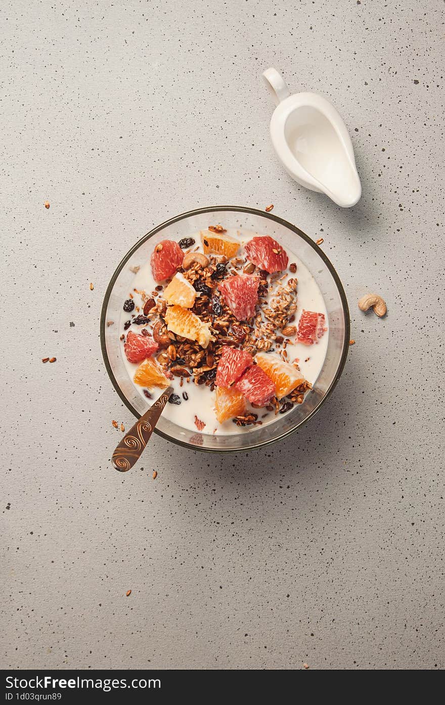 Granola & x28 muesli& x29  with milk, fruits & x28 orange and grapefruit& x29 , cashew nuts and raisins. Healthy breakfast concept. Perfect for phone wallpaper, stories background, food blog post photo and so on