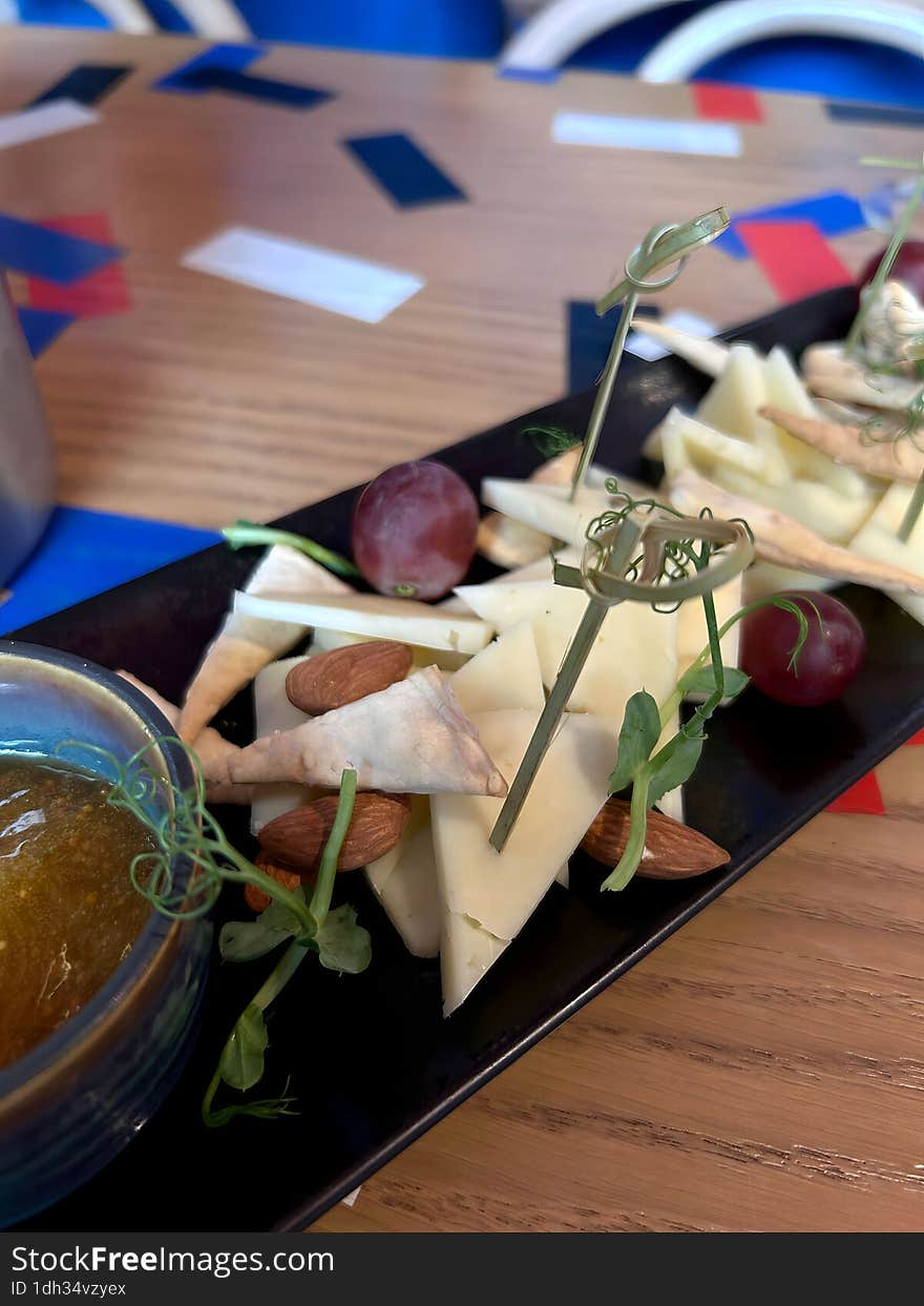 Cheese plate with jam, nuts and grapes