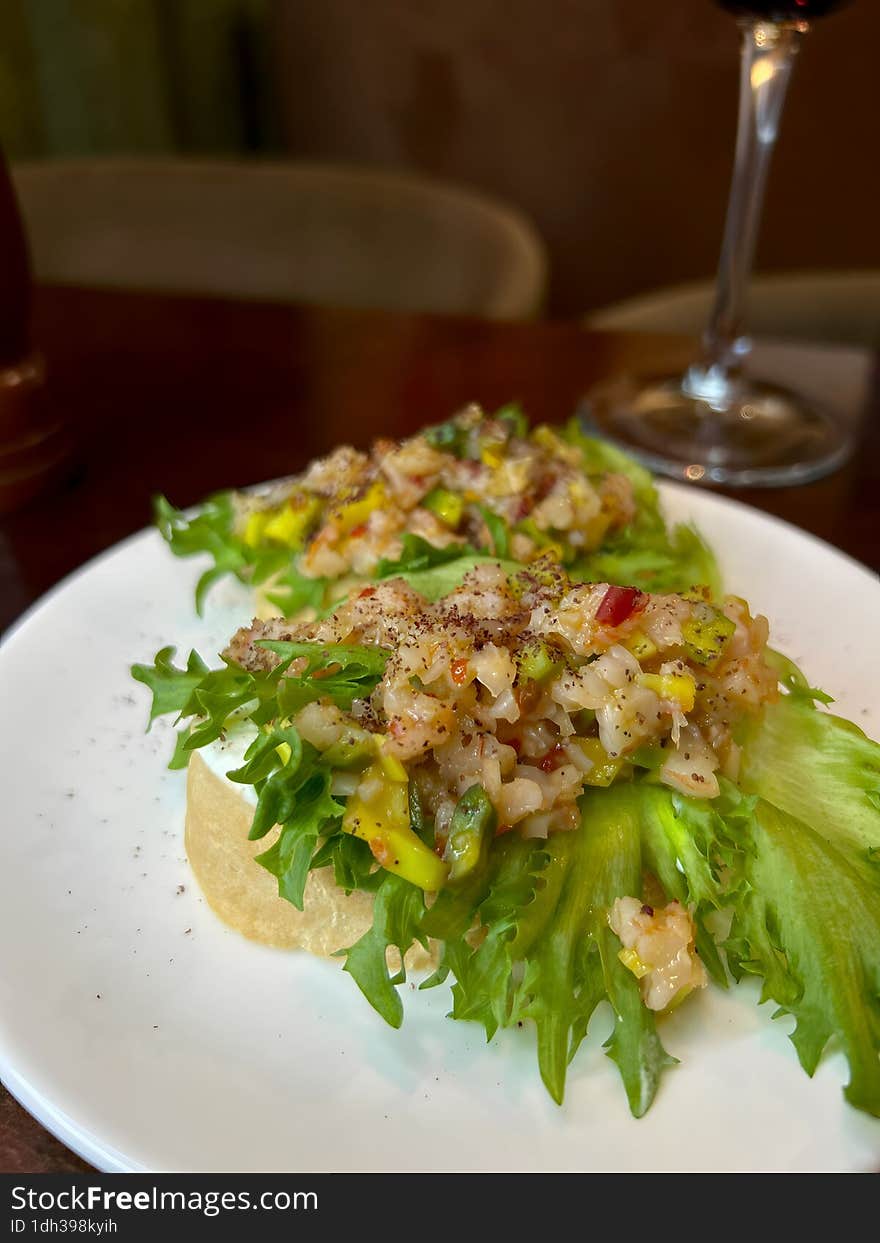 Two sandwiches with salad and meat on a round white plate