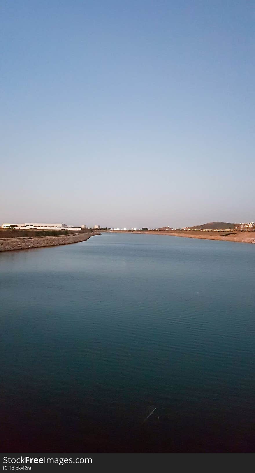 Enchanting beauty of a serene evening by the river as the setting sun casts its golden rays upon the tranquil waters