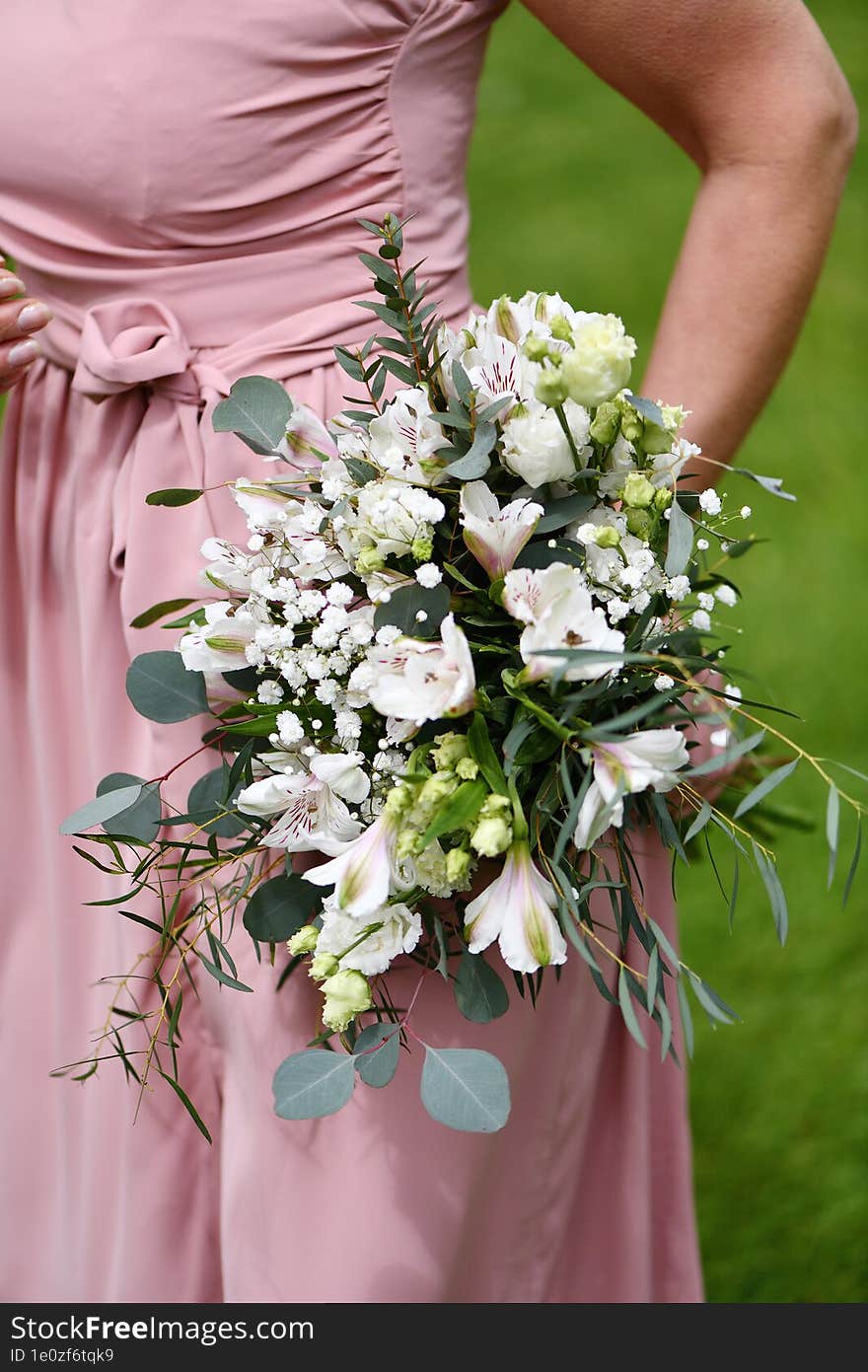 a young girl holds a bouquet of flowers in her hand. a young girl holds a bouquet of flowers in her hand