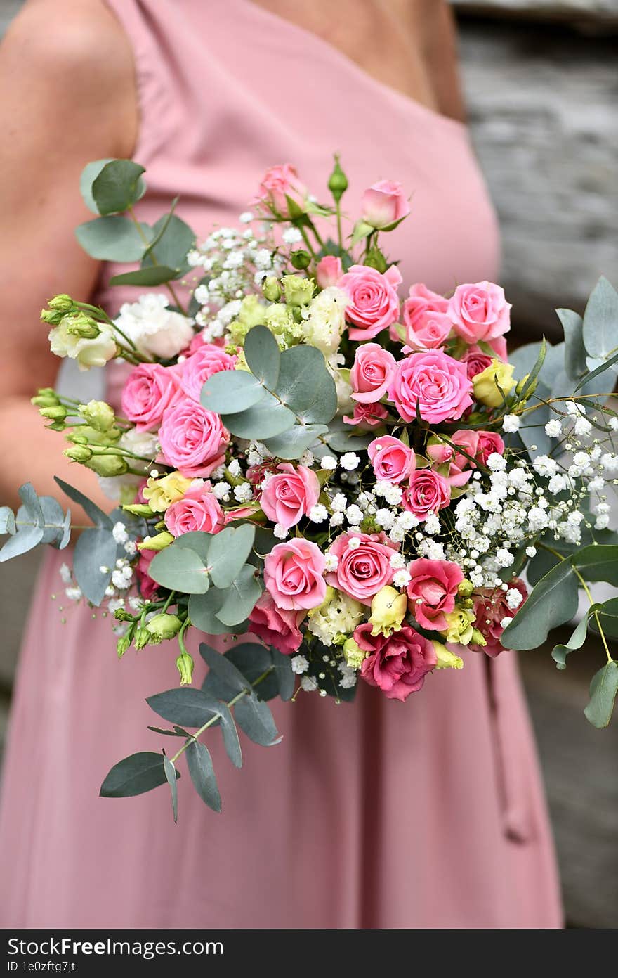 A Young Girl In A Pink Dress Holds A Bouquet Of Roses And White Flowers