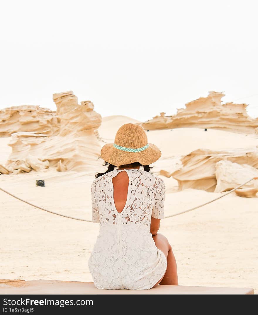 Female tourist visit sit on bench look at Fossil Dunes Structures. Abu Dhabi, UAE. Famous travel destination outside capitsl