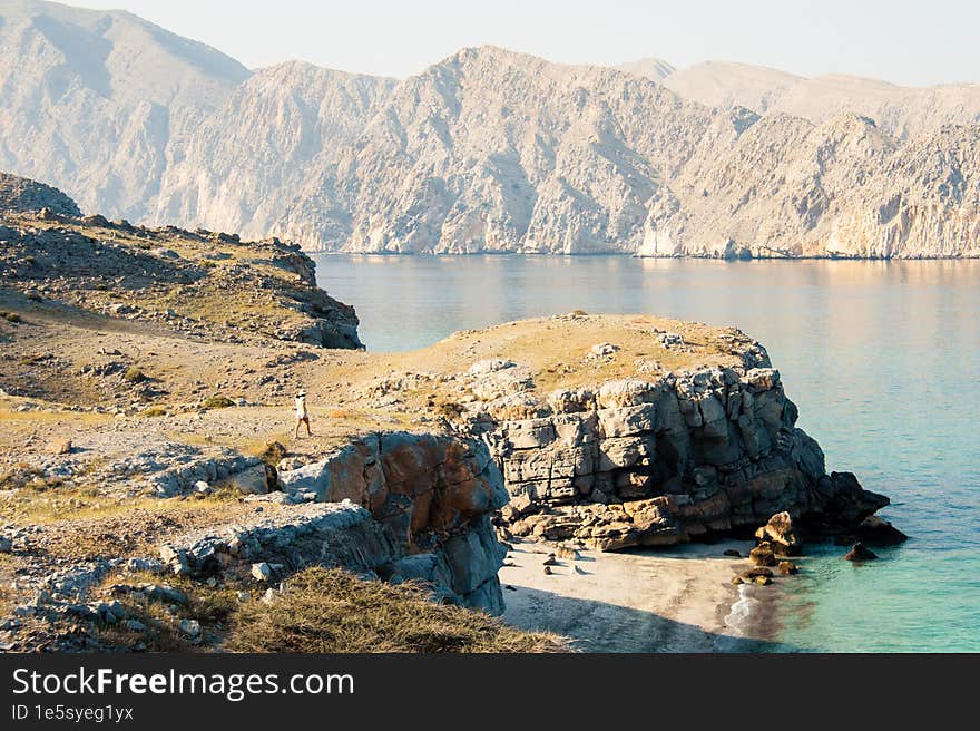 Aerial view tourist woman explore hike walk in Oman persian gulf Mirellas island on sunrise. Musandam.Oman