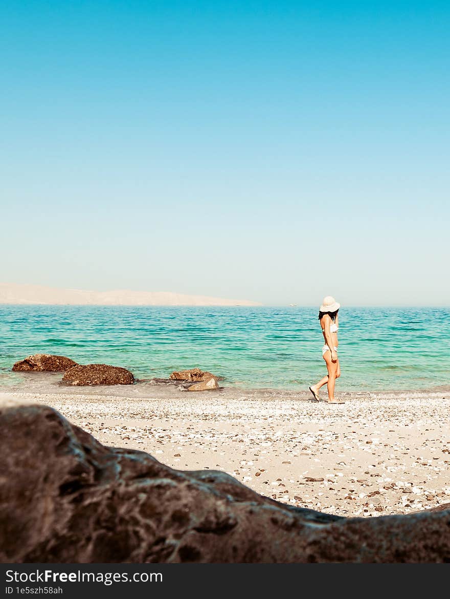 Panorama attractive caucasian tourist woman in white bikini walk on white sand beach alone explore middle east. Persian gulf Mirel