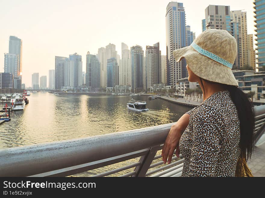 Dubai, UAE - 12th october, 2022: beautiful caucasian tourist woman in fashionable summer dress enjoy Dubai marina in United Arab Emirates. Luxury and comfortable tourism season