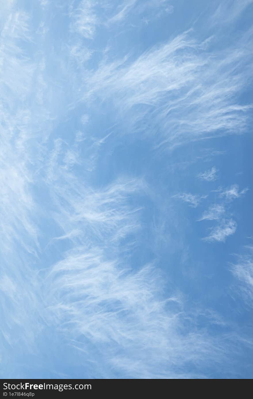 Wispy and transparent clouds. Vertical background with high gentle clouds.