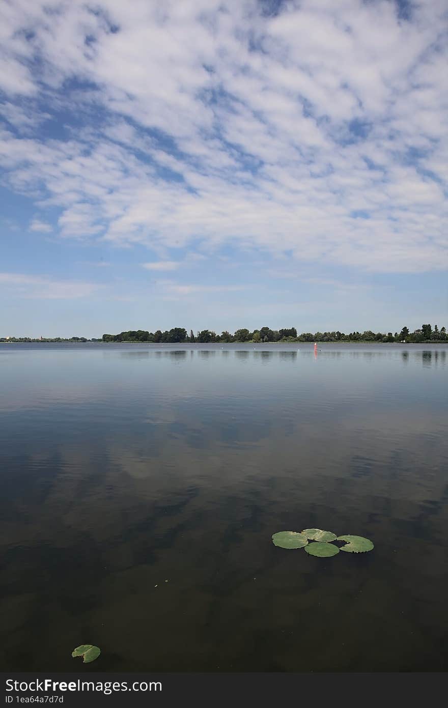 Lake and the opposite shore on the horizon on a summer day in the italian countryside