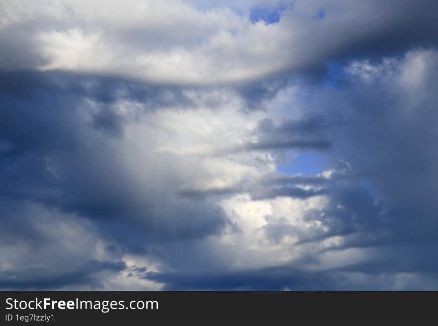 Large extended cumulus clouds illuminated by the afternoon summer sun on a cloudy day.