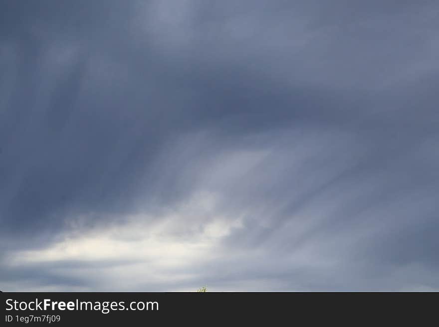 Large gray storm clouds of smooth and unusual shapes during a thunderstorm and a rainy day.