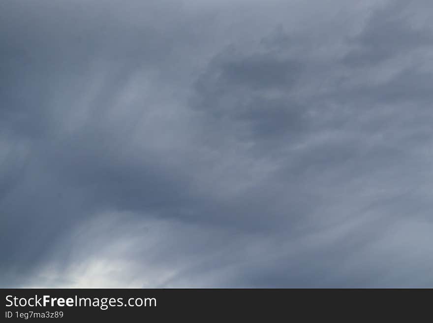 Large gray storm clouds of smooth and unusual shapes during a thunderstorm and a rainy day