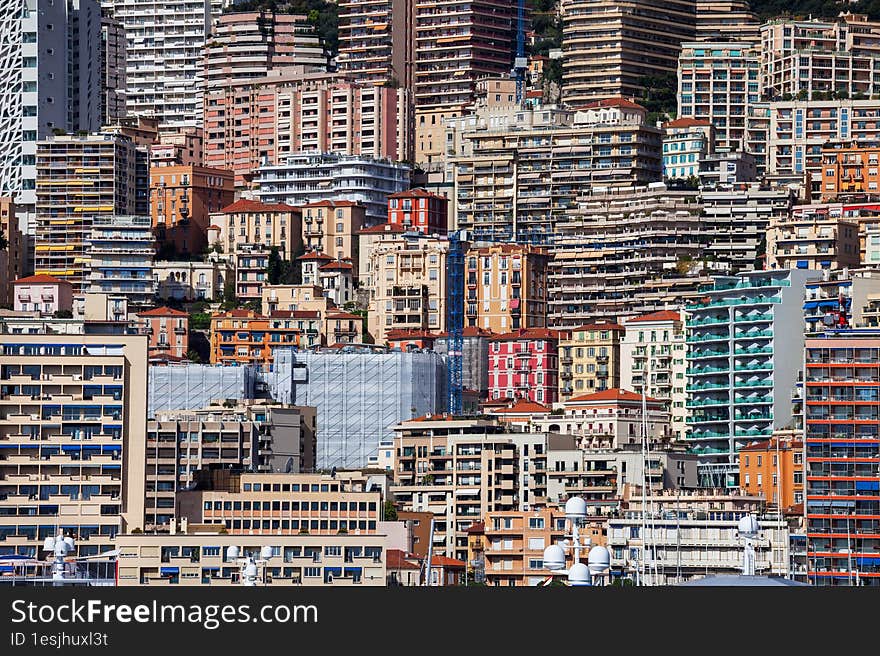 Principality of Monaco cityscape, densely populated urban background on mountain slope with houses, apartment buildings, towers, b