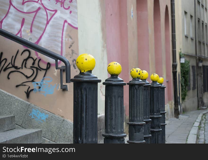 An old city street with yellow-headed posts placed in perspective