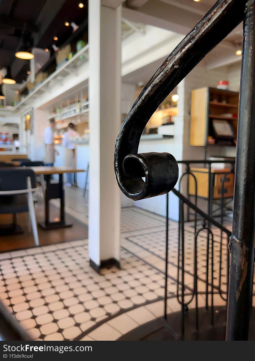 Black iron handle from the stairs in the bright interior of the restaurant