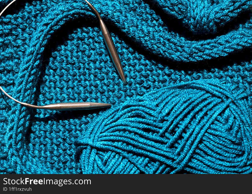 Turquoise winter knitwear is knitted using wool blend yarn. Handmade concept, hobby, fashionable online knitting course