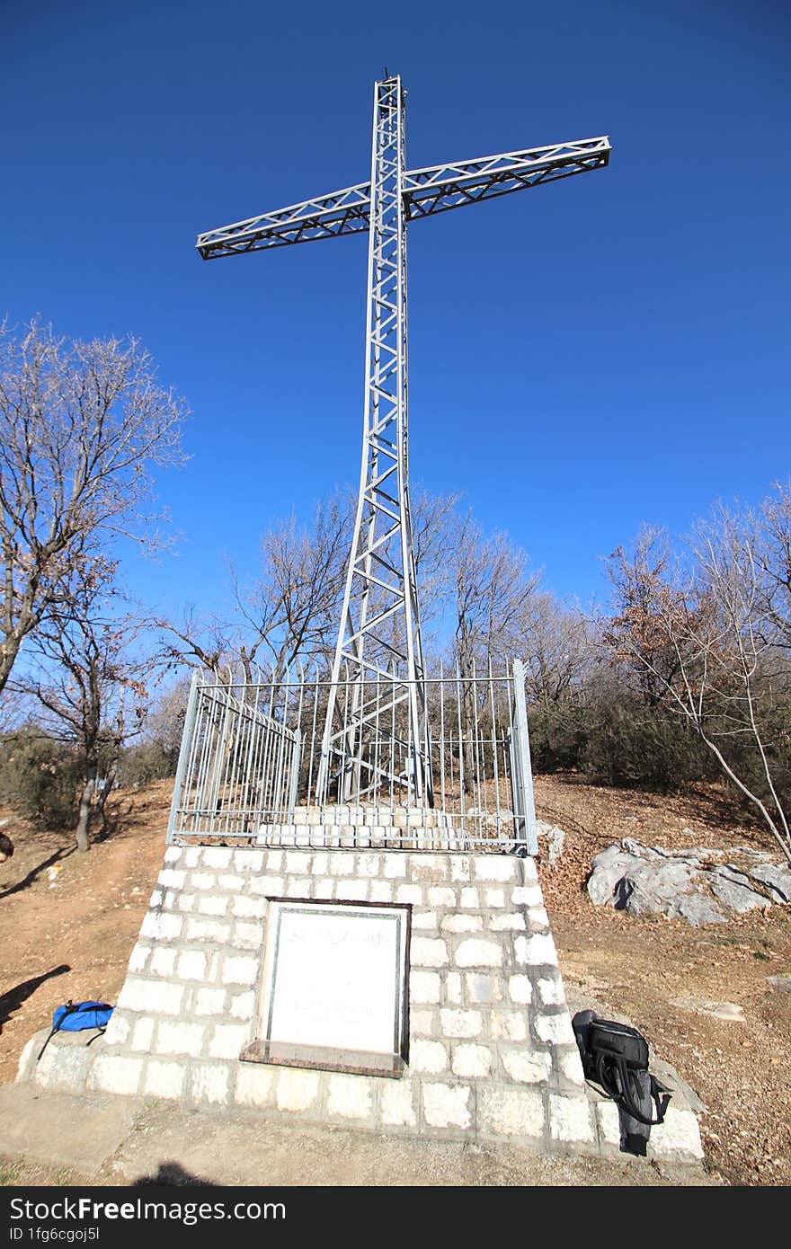 Christian cross on a mound against a blue sky with white clouds. Christian symbol. Religion and culture. Ukrainian Orthodox Church