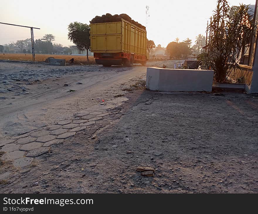 A Truck Containing Two Palm Oil Trees Was Passing On A Damaged Road