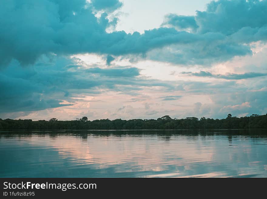 Beautiful View Of Clouds And Trees Reflecting On The Water. Beautiful Background