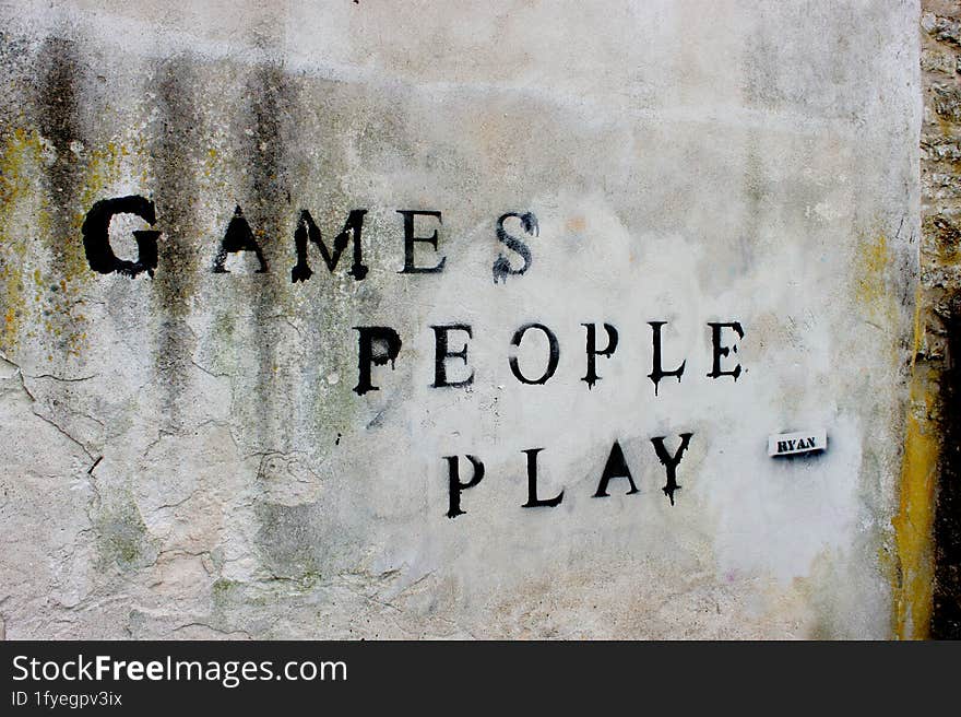 Sign on a wall Games people play. Vandalism, graffiti