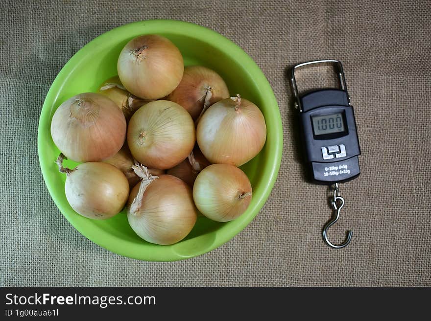 Onions in a plate and electronic bezmen on a burlap.