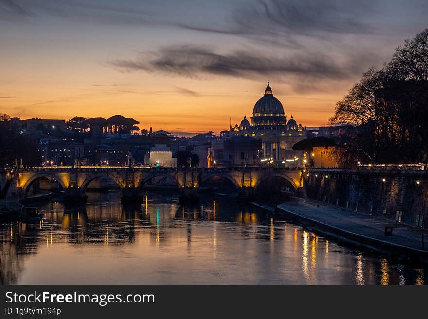 The Sant Angelo Bridge with Vatican silhouette during sunset in Rome, Italy