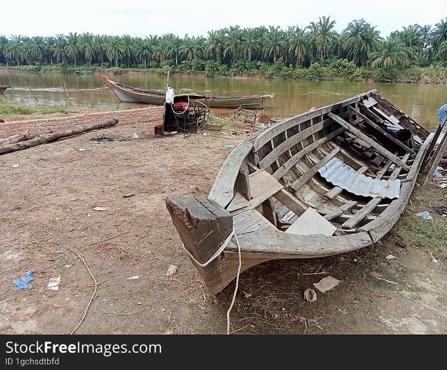 Old fishing boats are stranded on the riverbank and are no longer used. Old fishing boats are stranded on the riverbank and are no longer used